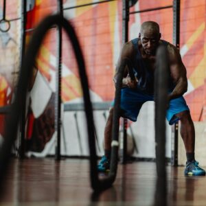 Fit adult man engaged in powerful workout using battle ropes for strength and endurance training.